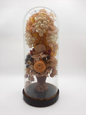 une cloche en verre contenant un bouquet de fruits