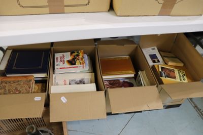 de nombreuses caisses de livres posées sur une étagère dans une pièce