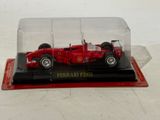 a red model of a racing car in a glass case