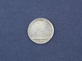 a close up of a silver coin on a blue cloth