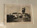 a black and white photo of a man standing over a herd of sheep