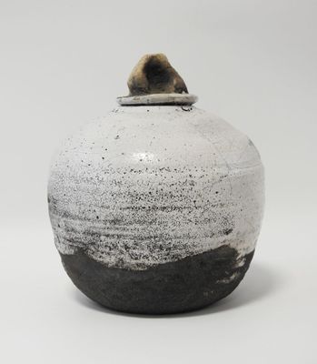 un vase noir et blanc posé sur une table blanche