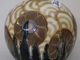 a black and white vase with a flower design on it