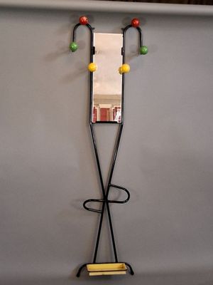 un miroir accroché au mur à côté d'un porte-manteau