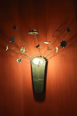 un vase contenant des fleurs, accroché au mur