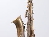 an old brass saxophone sitting on top of a wooden stand