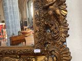a gold mirror hanging on a wall in a room