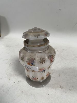 un petit vase muni d'un couvercle, posé sur une table