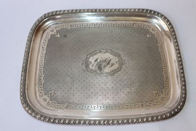 un plateau en argent ancien posé sur une table blanche, orné d'une image représentant un cheval
