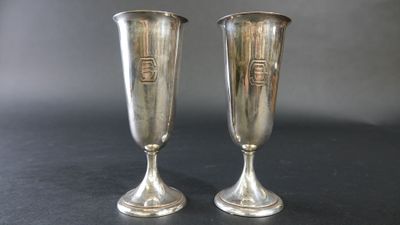 paire de vases plaqués argent sur un fond noir avec un arrière-plan gris