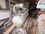 a small air compressor sitting in a garage with other equipment