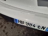 a close up of a white car with a number plate on it