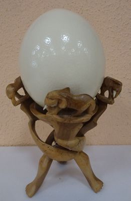 a white ball sitting on a wooden stand with a lamp on it