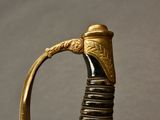 an old gold and black sword with a handle on a table