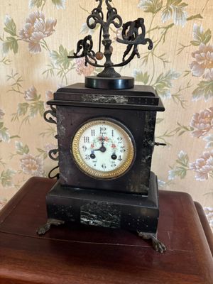 une petite horloge posée sur une table en bois