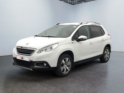 La voiture blanche est garée dans une grande pièce au sol noir.