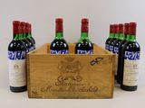six bouteilles de vin dans un coffret en bois muni d'une étiquette