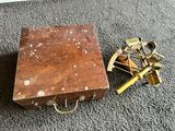 a small wooden box with a brass compass on it
