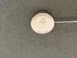 a close up of a coin with a needle sticking out of it