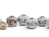 de nombreux vases alignés les uns à côté des autres sur une surface blanche