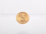 a close up of a gold coin on a white surface
