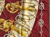 an image of a red and white scarf with a gold and silver design