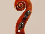 a close up of the back of a violin with a fiddle in the foreground