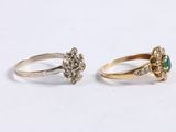 two gold rings with diamonds and a green stone
