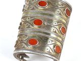an image of a silver bracelet with red stones on it