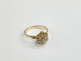 gros plan d'une bague en or sur une surface blanche