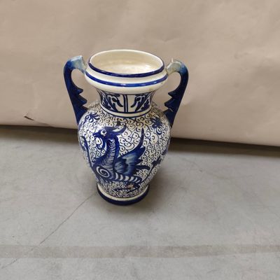 un vase bleu et blanc posé par terre