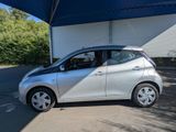 the small silver car is parked in front of a garage