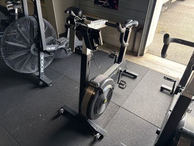 une salle de sport équipée d'un vélo d'appartement et d'un ventilateur