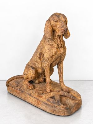 an old wooden statue of a dog sitting on top of a wooden block