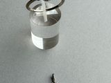 a small glass of water with a ring on top of it