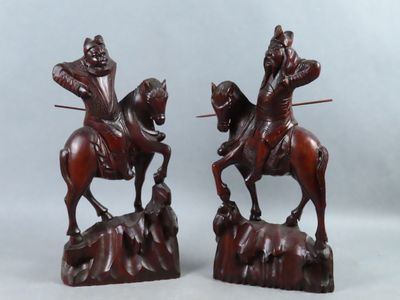paire de figurines en bois sculpté représentant un homme à cheval et un homme à cheval sur un rocher