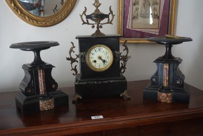 trois horloges posées sur une table, avec un miroir en arrière-plan
