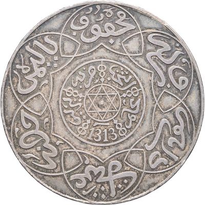 an old silver coin with arabic writing on the reverse side