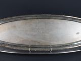 an oval silver tray on a black background with a black background