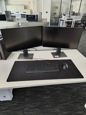 two computer monitors and a keyboard on a desk