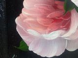 a painting of a pink rose in a black frame