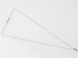 a close up of a gold necklace on a white surface
