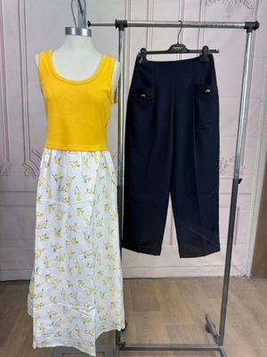 un haut jaune et un pantalon noir sur un présentoir pour mannequin