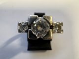 une photo d'une bague en diamant posée sur un socle noir