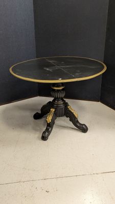 an image of a black and gold table on a white floor