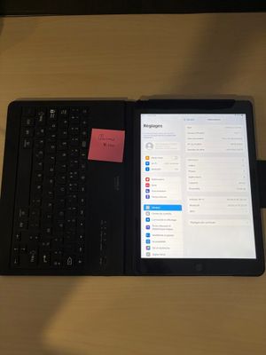un ordinateur portable et une tablette posés sur un bureau sur lequel se trouve un post-it