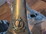 someone is holding a brass trumpet in their hand on a wooden floor