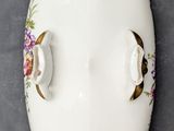 a white plate with gold decorations on it on the wall