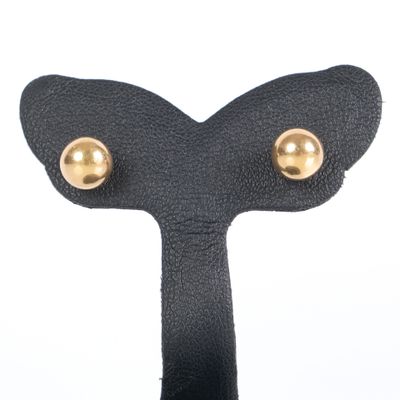 black leather and gold plated earrings on a hook on a white background