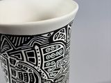 a black and white cup with a design on it
